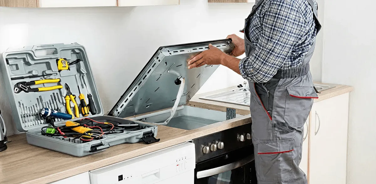 Handyman repairing a cooktop and checking wiring connections in Jackson, MS