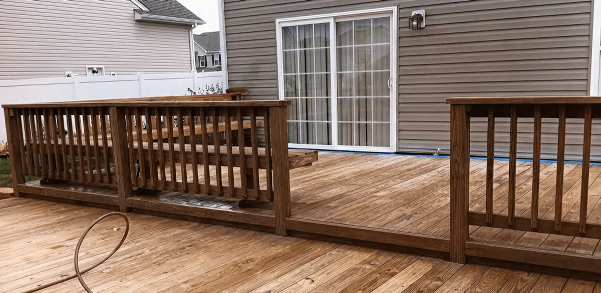 Deck sealing service protecting a backyard wood deck and railings in Jackson, MS