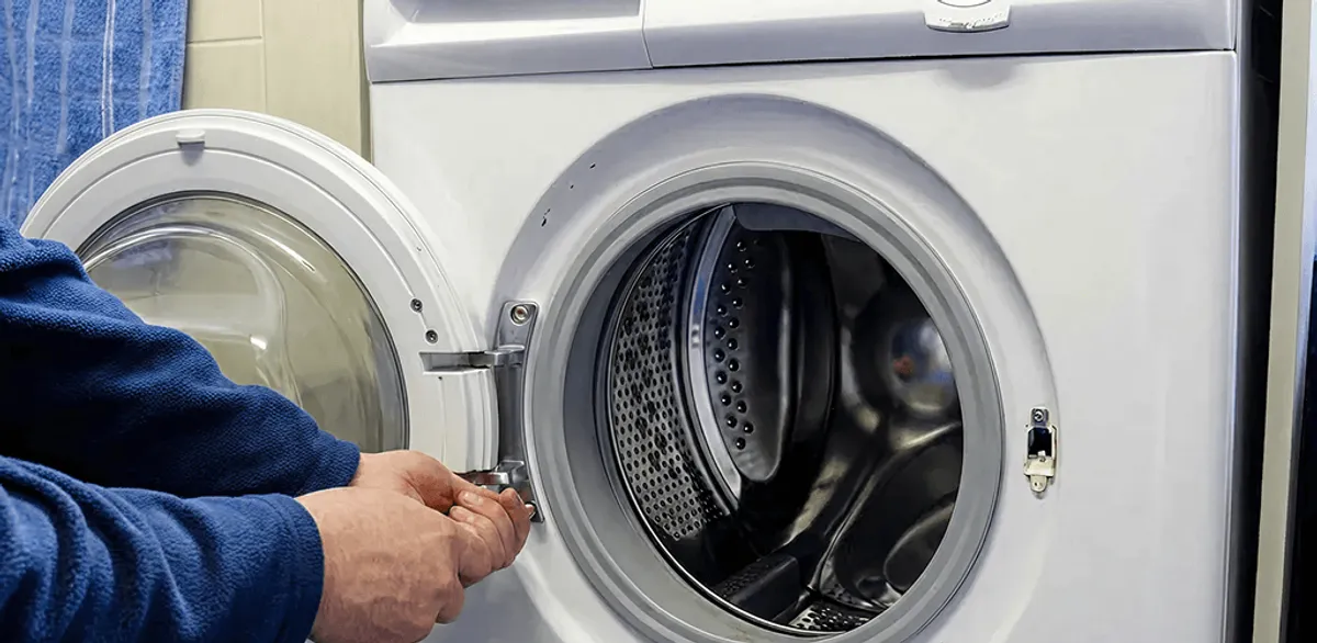 Washing machine repair handyman checking a front-load washer door and latch in Jackson, MS