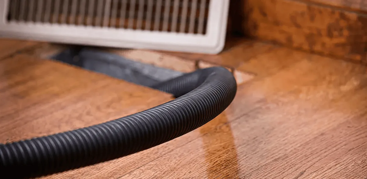 Air duct cleaning hose inserted into a floor vent for ductwork cleaning in Jackson, MS
